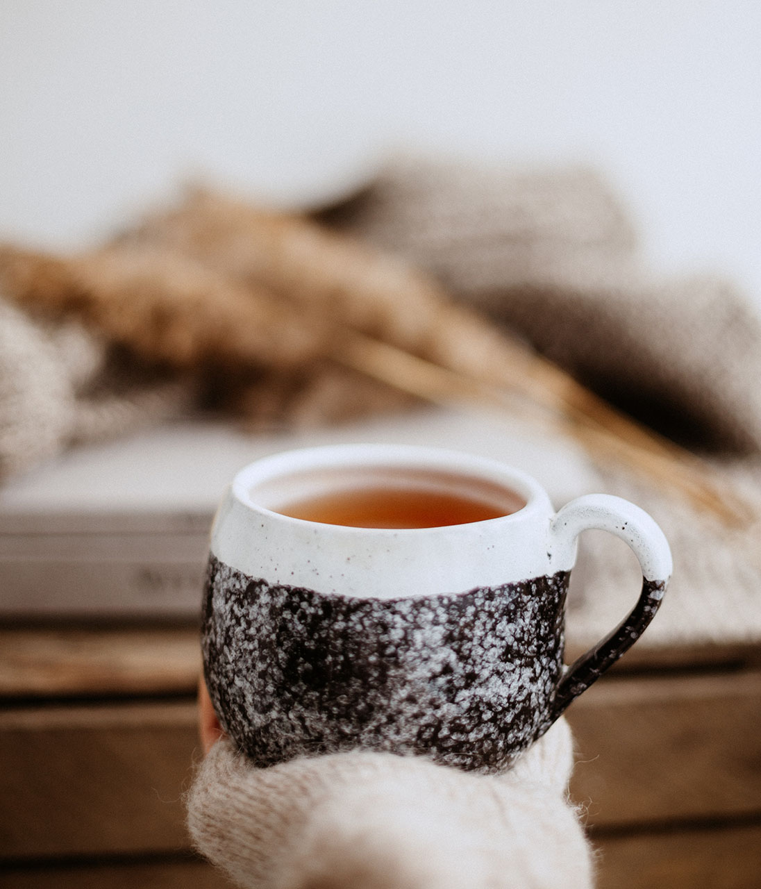 a woman's hand holding a cup of tea