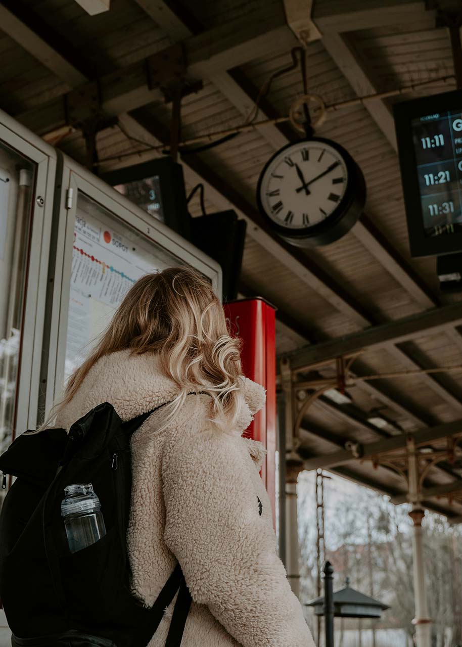 vrouw met rugzak op het station - slow travel