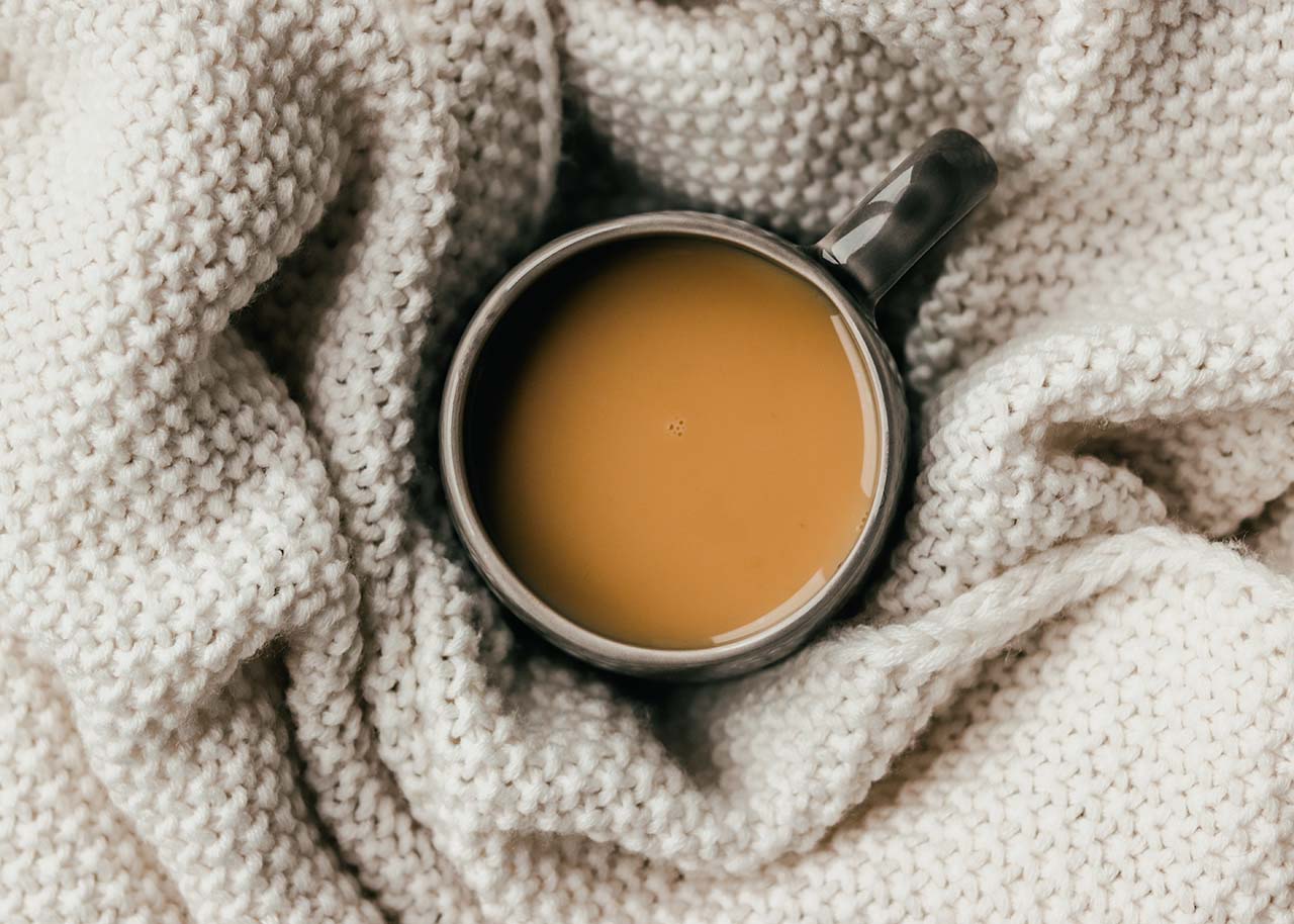 een kop koffie op een deken - warm in bed