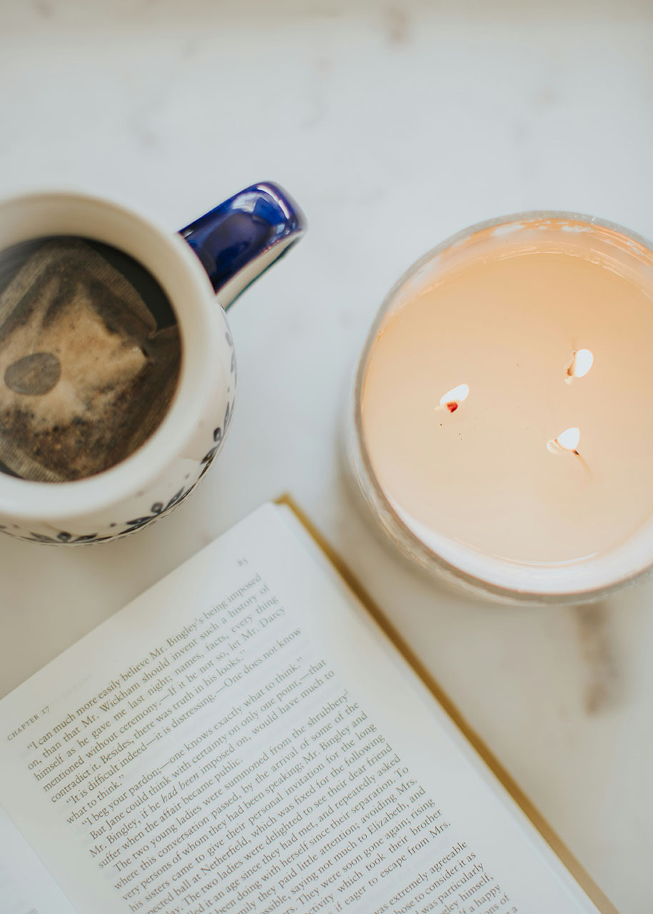 een kaars, een boek en een kop thee - winter hygge